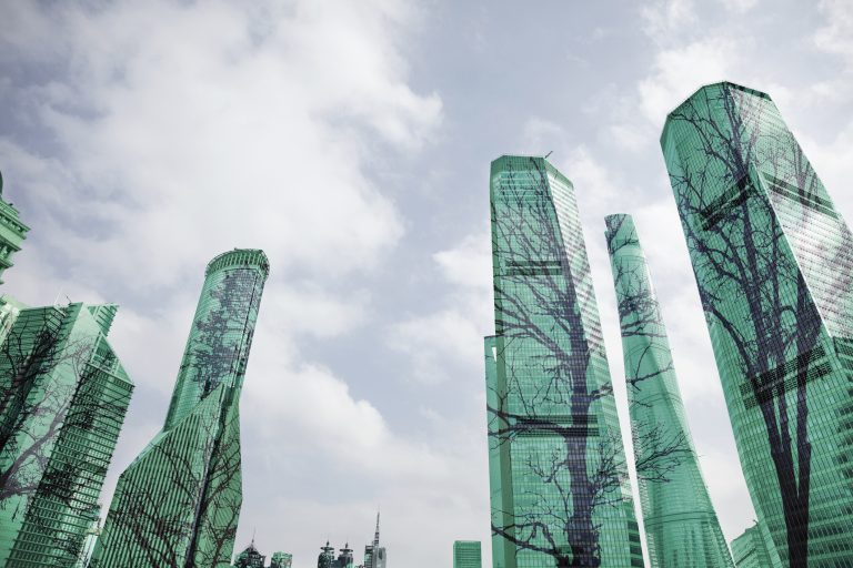 Composite image of trees on buildings in city as metaphor for ESG-investing on the rise